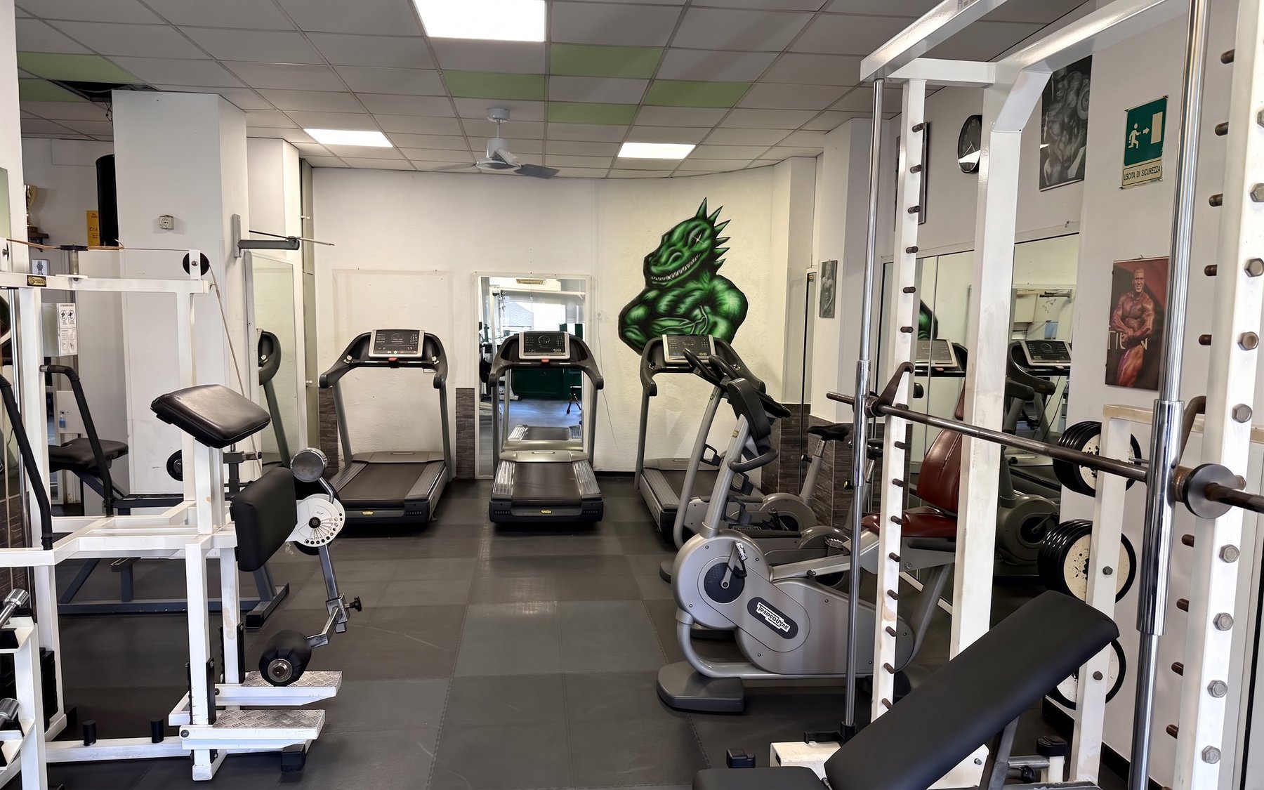 La sala della Tiranno Gym, con i tapis roulant e il murales del dinosauro